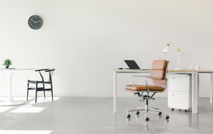 An open floor plan office space with a minimalist setup of chairs and desks